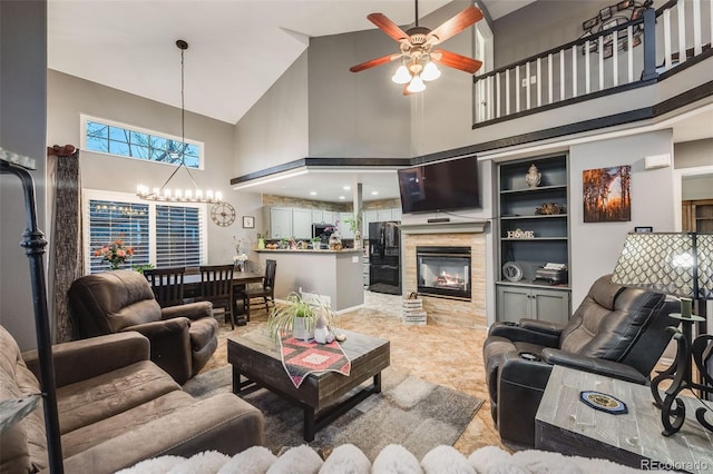 living room with a high ceiling and ceiling fan with notable chandelier