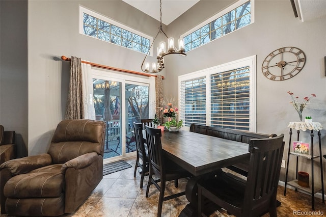 dining space with a towering ceiling and a notable chandelier