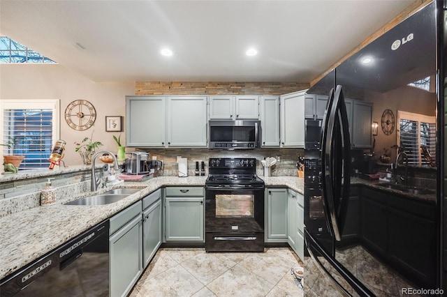 kitchen with light stone countertops, sink, and black appliances