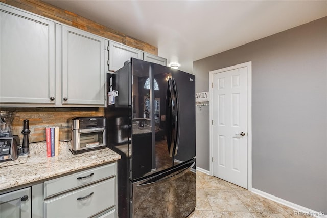 kitchen with black fridge and light stone counters