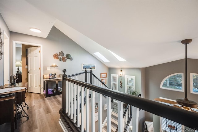 hall with hardwood / wood-style flooring and vaulted ceiling with skylight