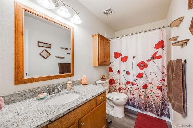 bathroom featuring vanity, hardwood / wood-style floors, curtained shower, and toilet