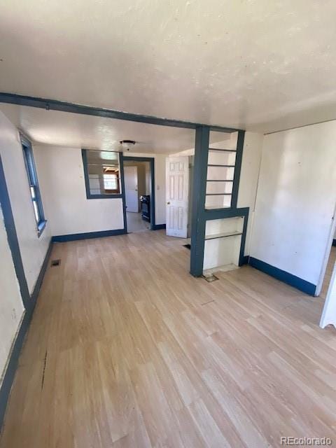 unfurnished room featuring baseboards and light wood finished floors