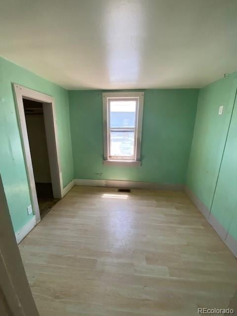 unfurnished bedroom featuring light wood-style floors and baseboards