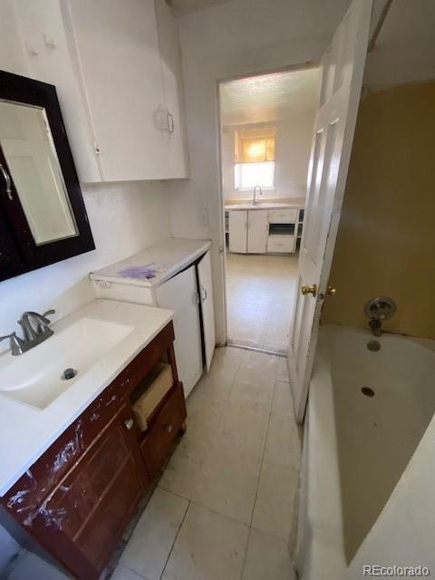 full bathroom with tile patterned floors, a bathtub, and vanity