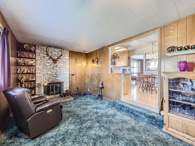 living room with carpet floors, a brick fireplace, and wood walls