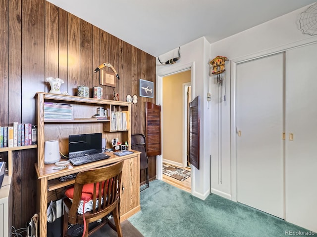 home office with carpet flooring and wooden walls