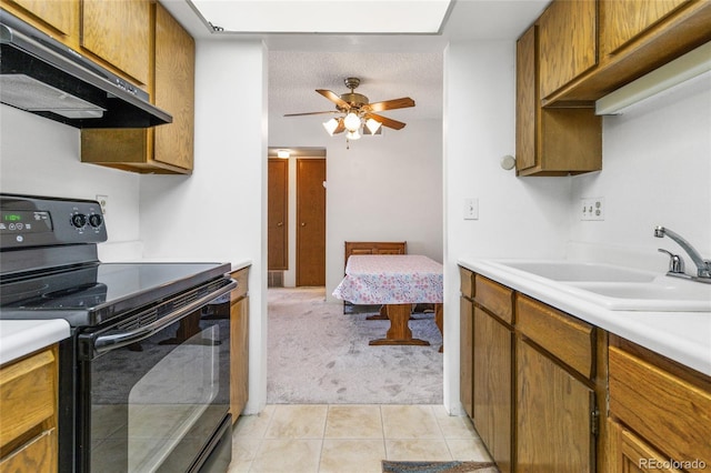 3550 S Harlan St Unit 214, Denver, CO 80235 - kitchen with electric range, under cabinet range hood, light colored carpet, light countertops, and light tile patterned floors