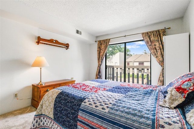 3550 S Harlan St Unit 214, Denver, CO 80235 - bedroom featuring access to outside, carpet, and a textured ceiling