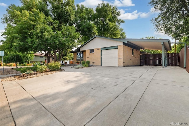 6290 Quail St, Arvada, CO 80004 - view of side of home featuring concrete driveway, an attached carport, brick siding, and an attached garage