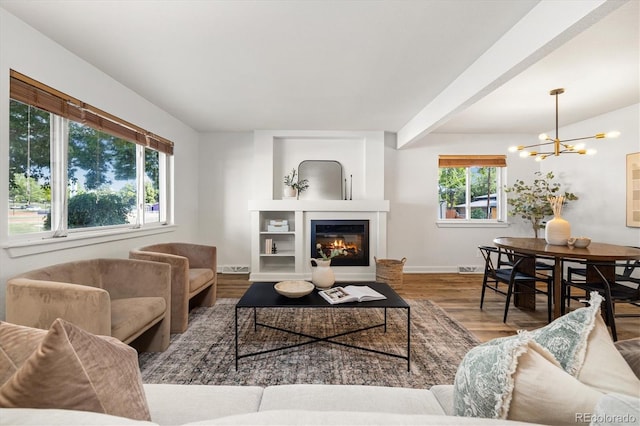 6290 Quail St, Arvada, CO 80004 - living area featuring a chandelier, wood finished floors, a glass covered fireplace, and beam ceiling