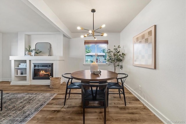 6290 Quail St, Arvada, CO 80004 - dining space featuring a chandelier, wood finished floors, and a glass covered fireplace