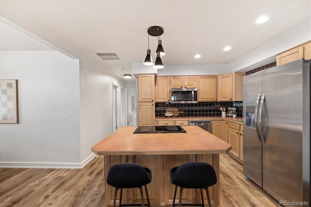 6290 Quail St, Arvada, CO 80004 - kitchen with stainless steel appliances, light brown cabinets, a kitchen bar, decorative backsplash, and recessed lighting
