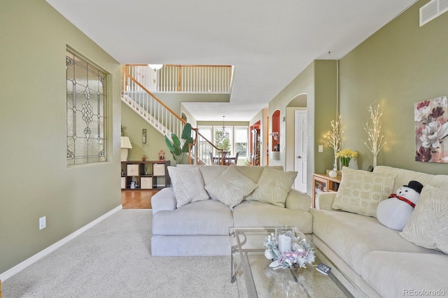 9536 W Avalon Dr, Littleton, CO 80127 - living area with arched walkways, baseboards, stairs, and carpet