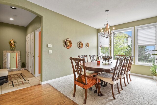 9536 W Avalon Dr, Littleton, CO 80127 - dining space with arched walkways, a chandelier, plenty of natural light, baseboards, and a textured wall