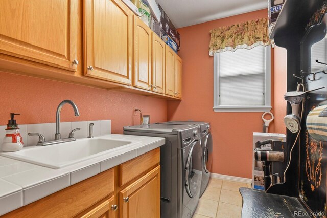 9536 W Avalon Dr, Littleton, CO 80127 - laundry area with cabinet space, washing machine and clothes dryer, light tile patterned floors, and baseboards