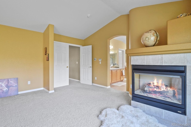 9536 W Avalon Dr, Littleton, CO 80127 - living area with vaulted ceiling, carpet flooring, baseboards, a fireplace, and arched walkways