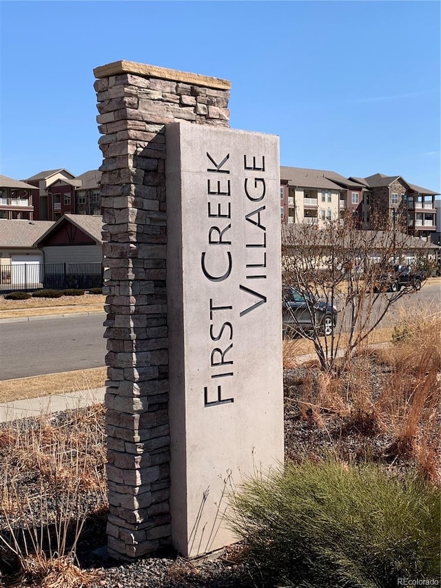 community / neighborhood sign with fence and a residential view