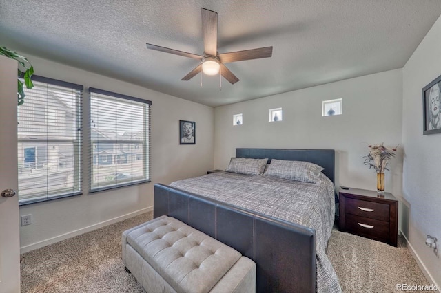 bedroom with carpet floors, a ceiling fan, baseboards, and a textured ceiling