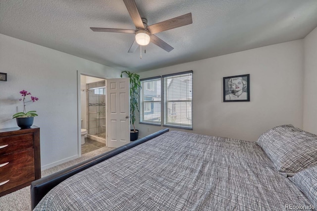 bedroom featuring a textured ceiling, baseboards, a ceiling fan, and ensuite bathroom