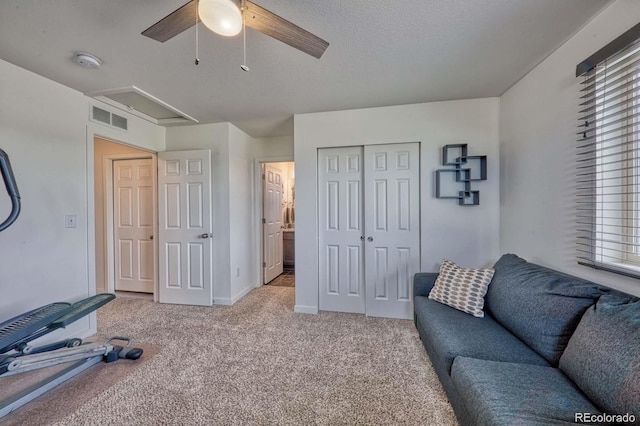 exercise area featuring a textured ceiling, ceiling fan, visible vents, baseboards, and carpet