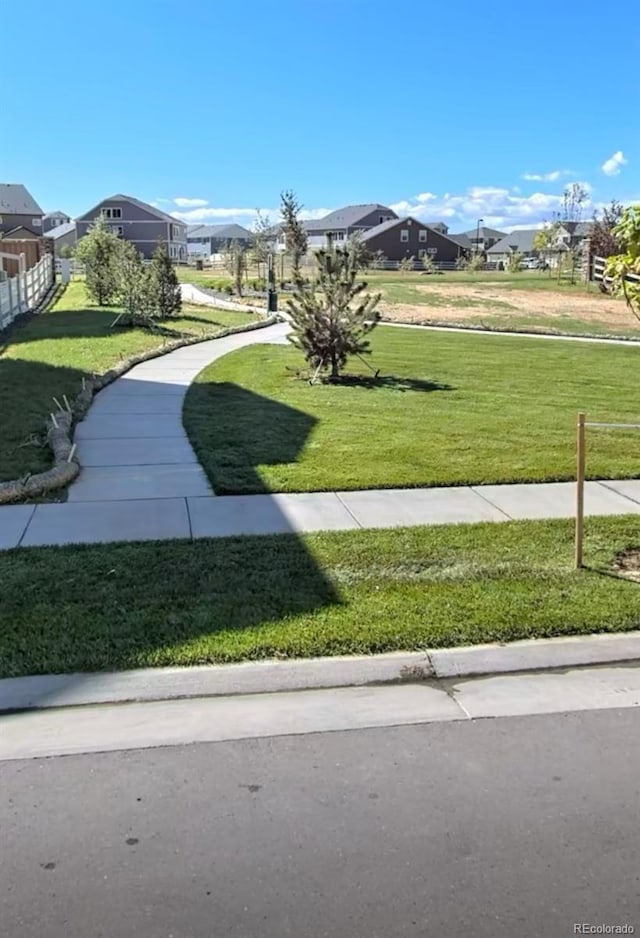 surrounding community with a yard and a residential view