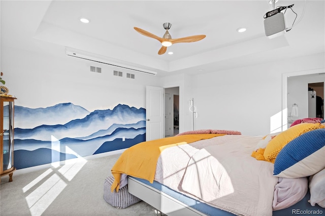 carpeted bedroom with ceiling fan and a raised ceiling