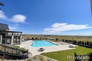 view of pool with a patio area and a yard