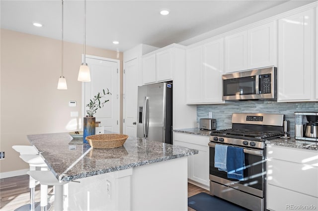 kitchen with white cabinetry, appliances with stainless steel finishes, and wood finished floors