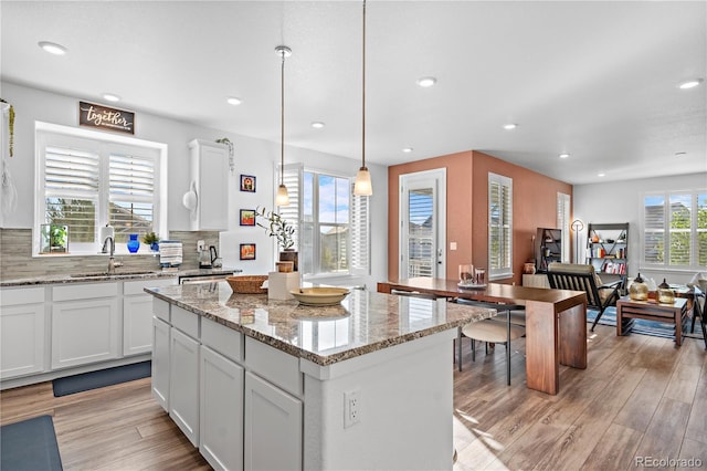 kitchen with a sink, a center island, light wood-type flooring, and recessed lighting