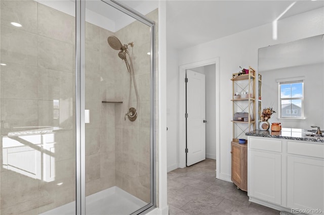 bathroom with vanity, baseboards, and a shower stall