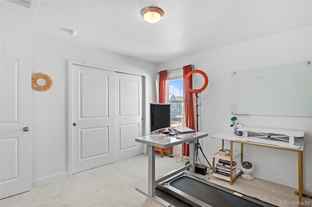 office with baseboards and light carpet