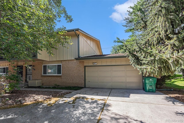 360 Upham St, Lakewood, CO 80226 - view of property with concrete driveway, a garage, brick siding, and board and batten siding