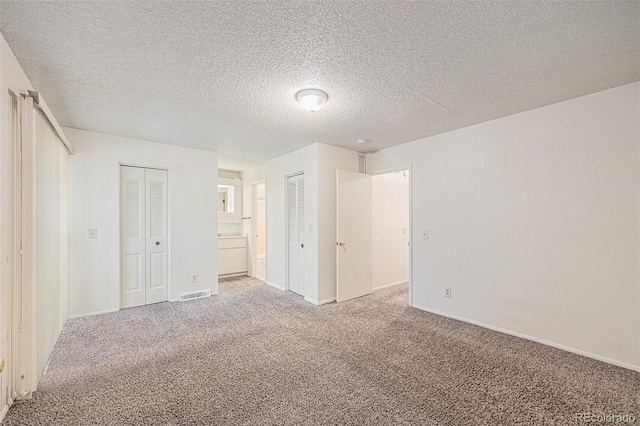 360 Upham St, Lakewood, CO 80226 - unfurnished bedroom featuring light colored carpet, multiple closets, and a textured ceiling