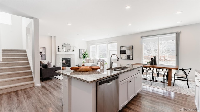 17850 W 94th Dr, Arvada, CO 80007 - kitchen featuring stainless steel dishwasher, a sink, light wood-style flooring, light stone counters, and recessed lighting