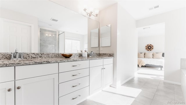 17850 W 94th Dr, Arvada, CO 80007 - ensuite bathroom featuring double vanity, a stall shower, and baseboards