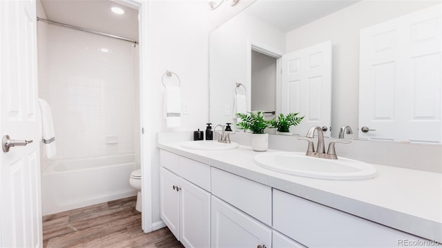 17850 W 94th Dr, Arvada, CO 80007 - full bath with double vanity, toilet, wood finished floors, and shower / tub combination