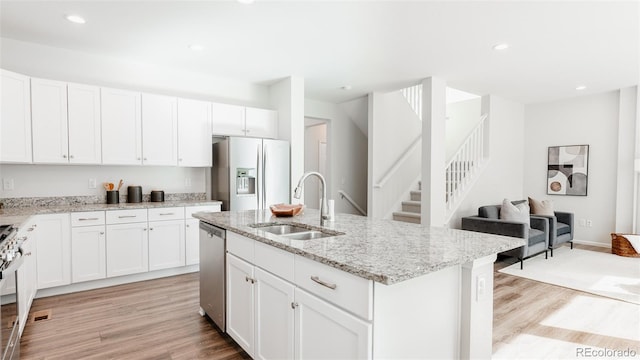 17850 W 94th Dr, Arvada, CO 80007 - kitchen featuring stainless steel appliances, a sink, light wood-style floors, light stone countertops, and recessed lighting