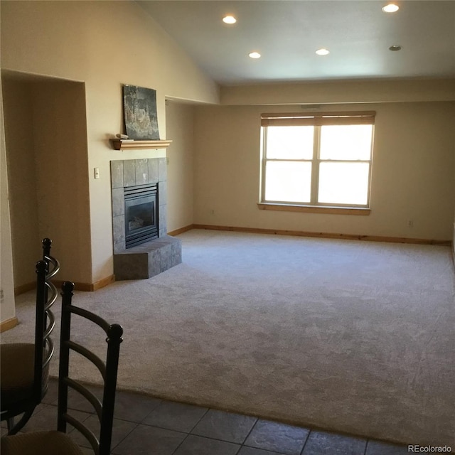 unfurnished living room featuring lofted ceiling, recessed lighting, carpet floors, a fireplace, and baseboards