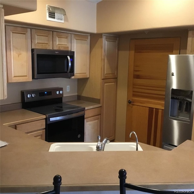 kitchen featuring stainless steel fridge, electric range, light countertops, and visible vents