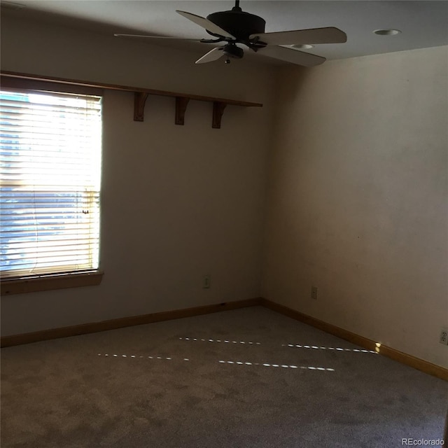 spare room featuring carpet, a ceiling fan, and baseboards