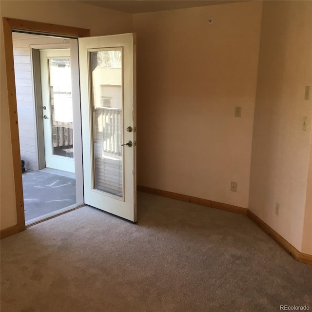 unfurnished room featuring carpet flooring and baseboards