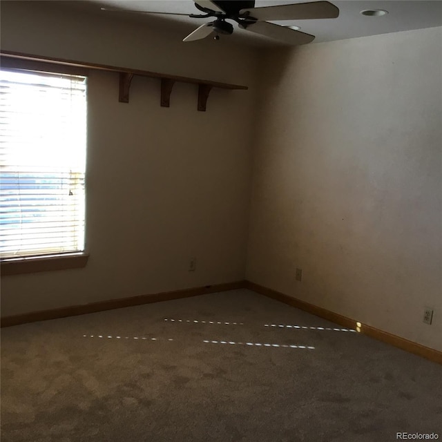 spare room featuring carpet flooring, baseboards, and a ceiling fan