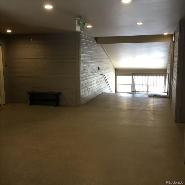 interior space featuring recessed lighting, wood walls, and concrete flooring