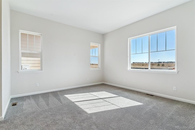 carpeted empty room with visible vents and baseboards