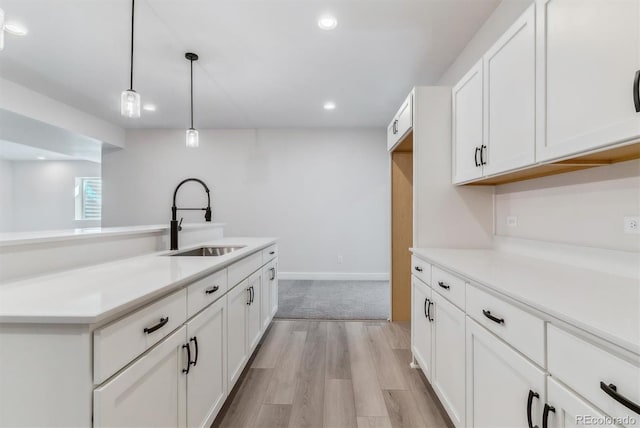 kitchen with white cabinets, a sink, and light countertops