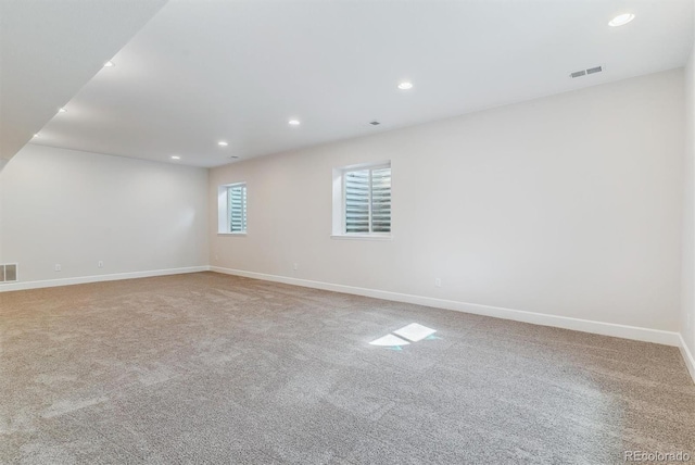 empty room featuring carpet, visible vents, baseboards, and recessed lighting