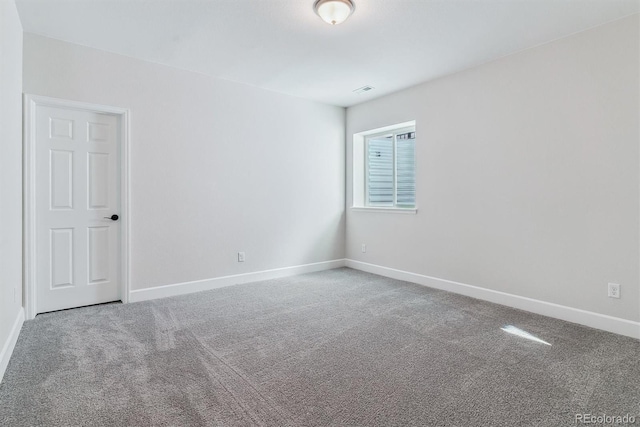 carpeted spare room featuring baseboards