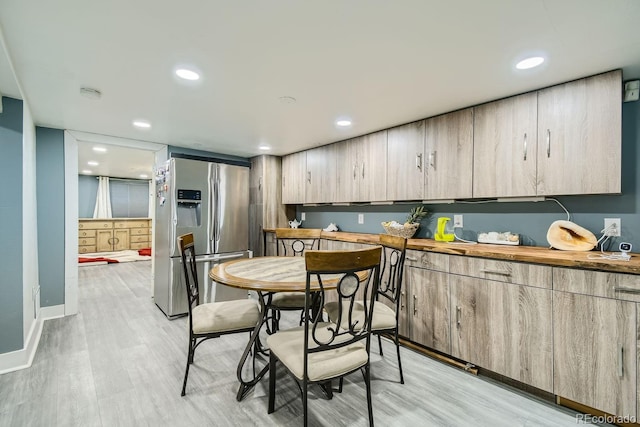 kitchen featuring light brown cabinetry, wooden counters, light hardwood / wood-style flooring, and stainless steel refrigerator with ice dispenser