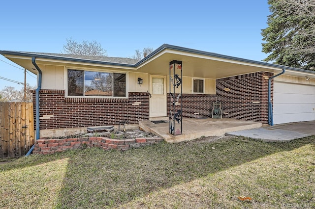 view of front of home featuring brick siding, a front yard, a garage, and fence